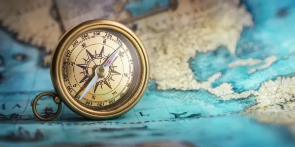 Map with a compass sitting on top